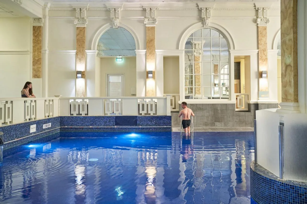 a man standing in the water in a swimming pool at The Dilly in London